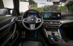 BMW I4 M50 interior view front on multifunctional steering wheel and infotainment screen 